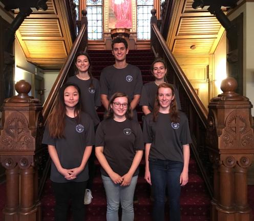 Georgetown student guards smiling for a picture on the stairs in Healy Hall.