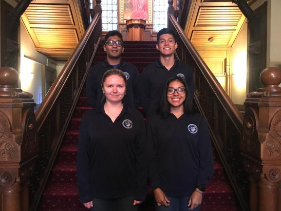 Georgetown student guards smiling for a picture on the stairs in Healy Hall.