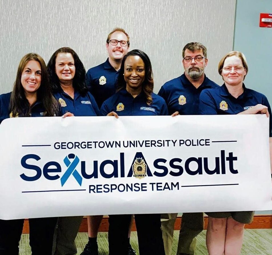 Members of Georgetown's Sexual Assault Response team smile for a photo holding a banner reading, "Georgetown University Police Sexual Assault Response Team."