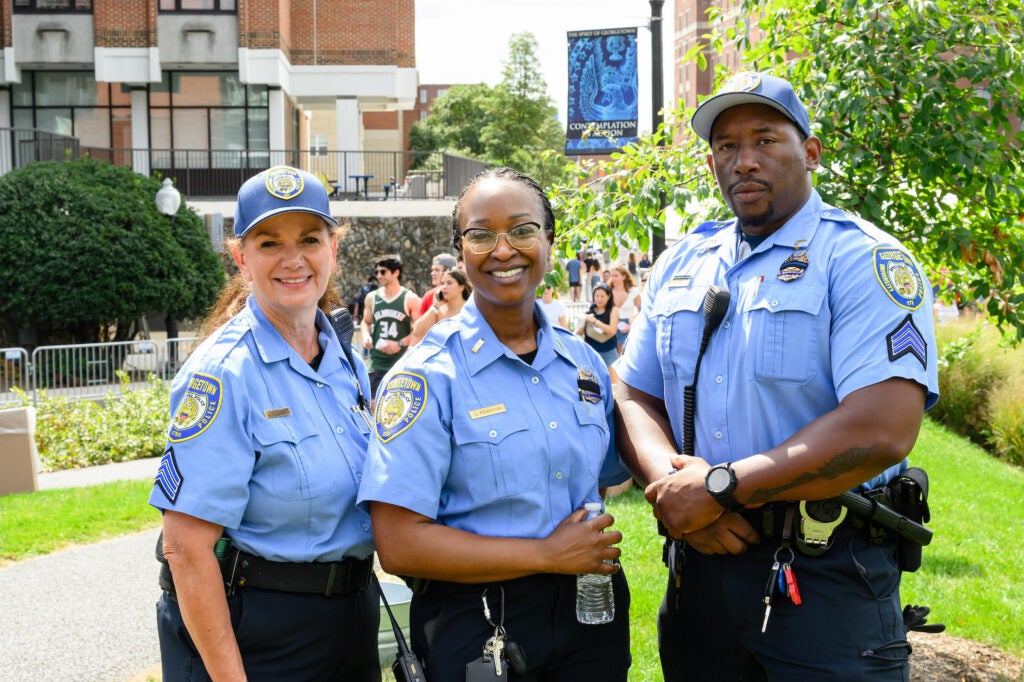 Three GUPD officers smiling outside.